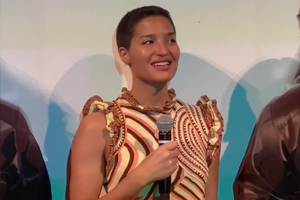 Indya Moore a Haitian, Puerto Rican, and Dominican transgender and non-binary person, speaks into a microphone.